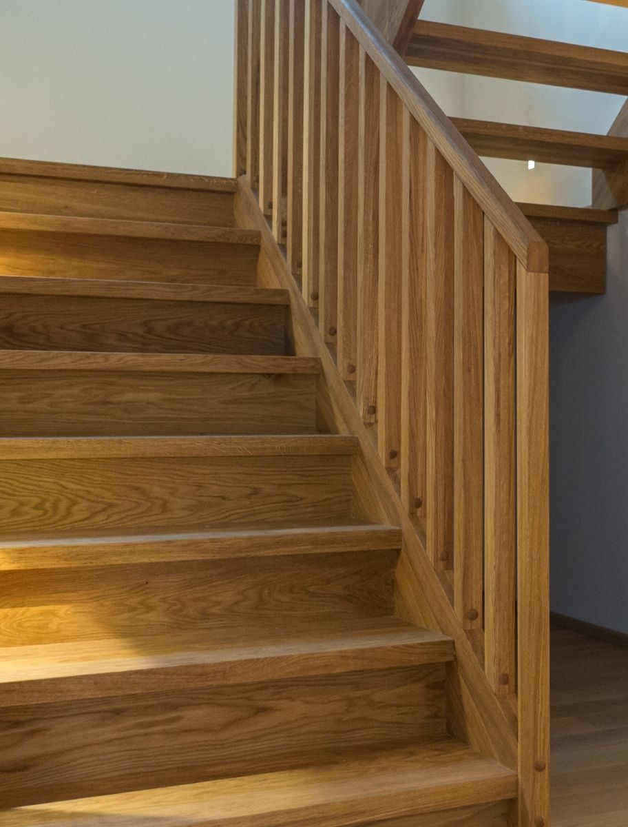 A wooden staircase with a smooth, natural finish, treated with a matt hard wax coating finish. The oil/varnish hybrid enhances durability while maintaining a warm, natural look.
