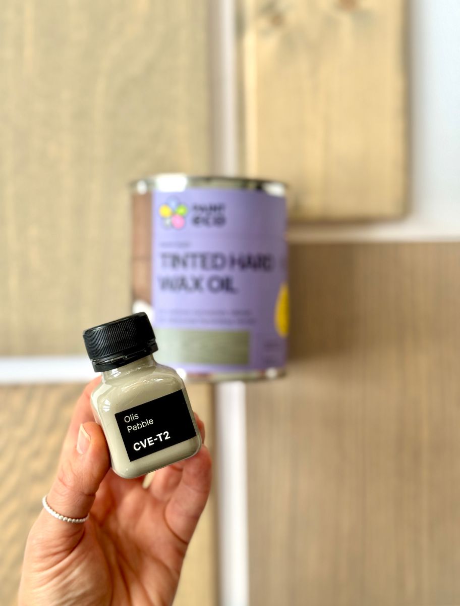 Small Paint Eco hard wax oil sample bottle held in hands