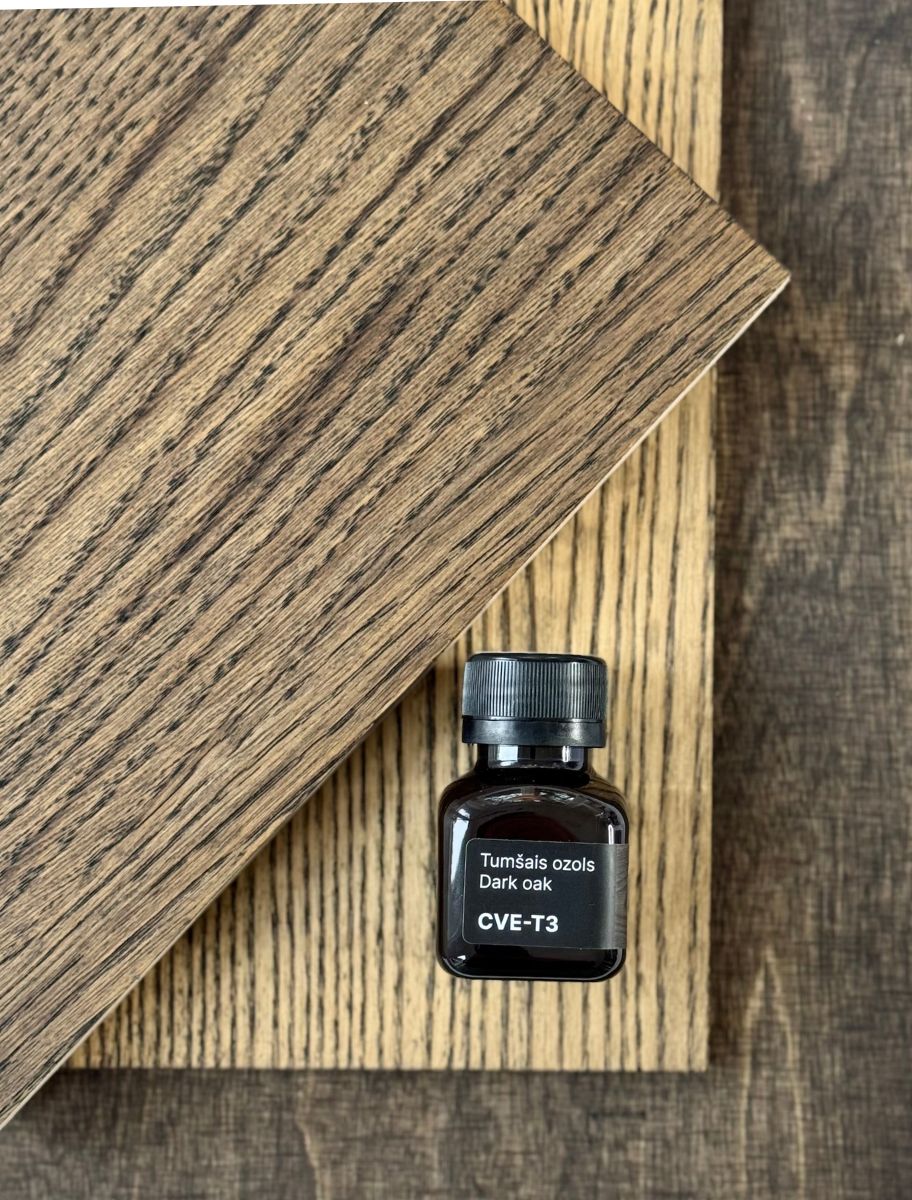 Small bottle of Paint Eco Tinted Hard Wax Oil in "Dark Oak" (CVE-T3) placed on wooden samples showcasing the finished wood texture.