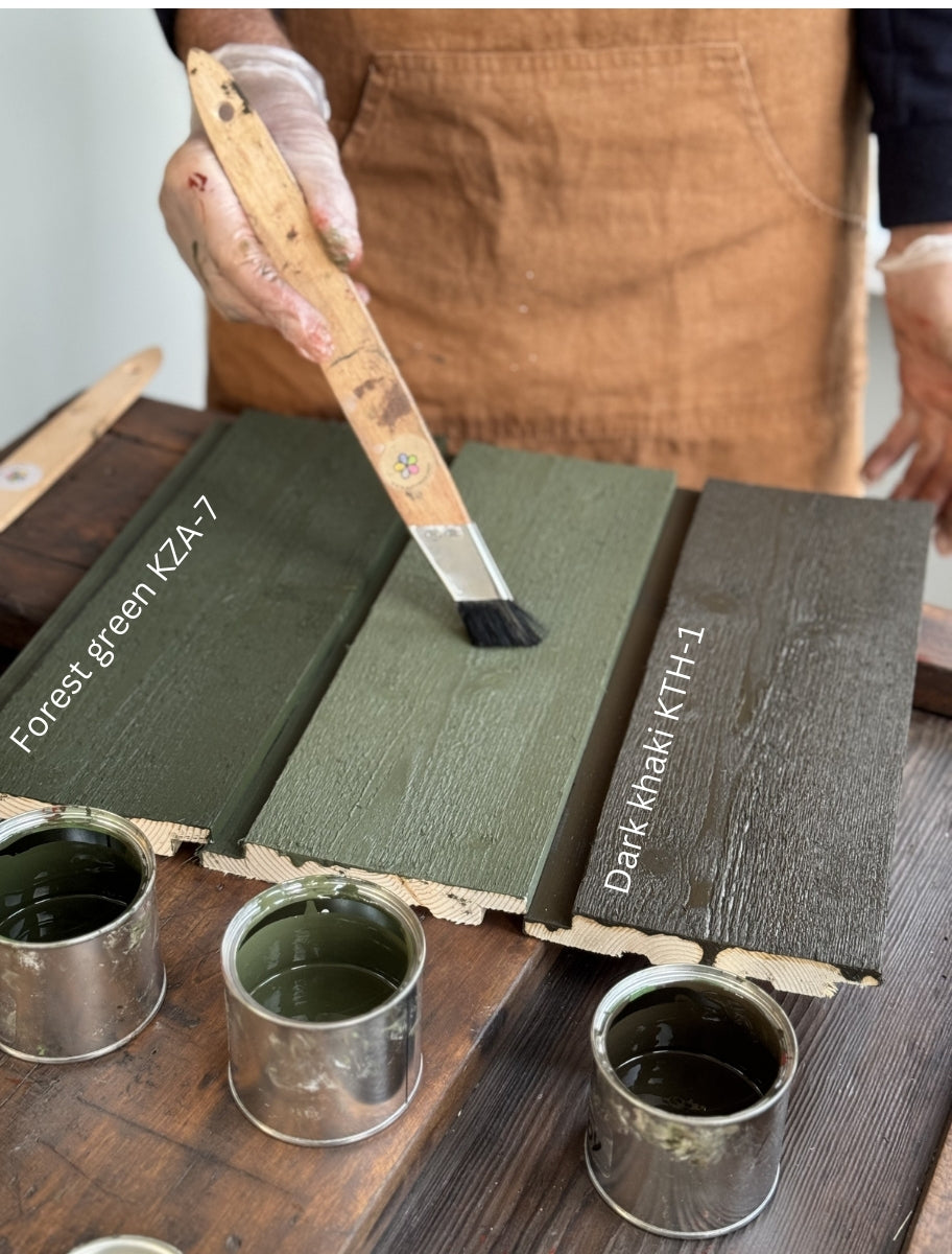 Application of linseed oil paint on wooden boards in two shades: Forest Green (KZA-7) and Dark Khaki (KTH-1), demonstrating smooth coverage and natural pigment richness.