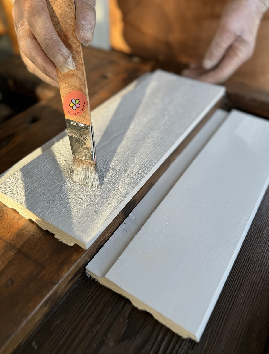 Application of Paint Eco linseed oil paint on wood using a brush, ensuring even coverage and protection.